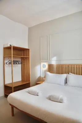 a bedroom with a large white bed with a wooden headboard at Domus Maxima - Rome Suite & Rooms in Rome