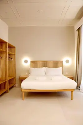 a bedroom with a white bed with two night stands at Domus Maxima - Rome Suite & Rooms in Rome