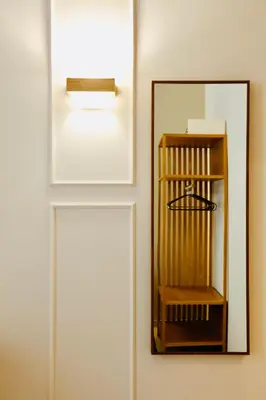 a mirror on a wall next to a light at Domus Maxima - Rome Suite & Rooms in Rome