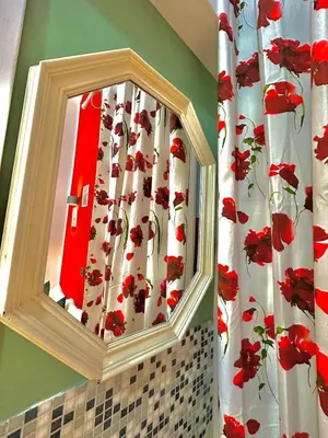 a mirror in a bathroom with a red and white shower curtain at B&B Termini Colosseo Suite in Rome