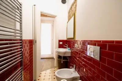 a red tile bathroom with a toilet and a sink at HC - In the heart of Campo de' Fiori in Rome