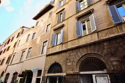 a stone building with blue shutters on it at HC - In the heart of Campo de' Fiori in Rome
