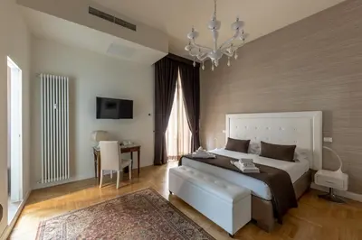 a bedroom with a large bed and a chandelier at Blue Inn Luxury Suites in Rome