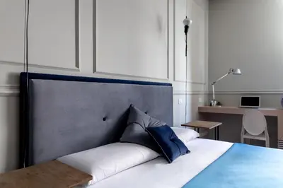 a bedroom with a large bed with blue pillows at Blue Inn Luxury Suites in Rome