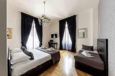a bedroom with a bed and a couch at Blue Inn Luxury Suites in Rome