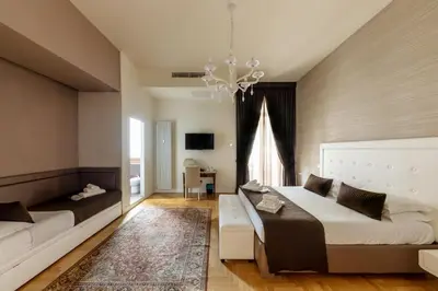 a bedroom with two beds and a chandelier at Blue Inn Luxury Suites in Rome