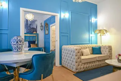 a living room with blue walls and a couch at Via Veneto 116 Suites - Guest House in Rome