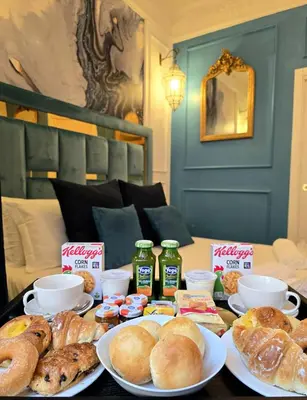 a table topped with plates of bread and pastries at Via Veneto 116 Suites - Guest House in Rome