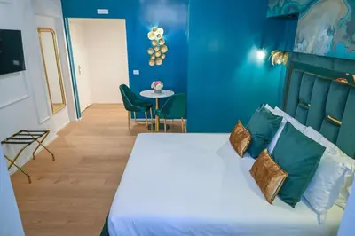 a bedroom with a bed with blue walls and a table at Via Veneto 116 Suites - Guest House in Rome