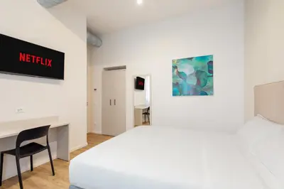 a hotel room with a bed and a desk at Adelante Apartment in Rome