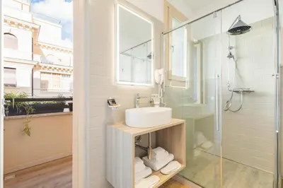a bathroom with a sink and a glass shower at Adelante Apartment in Rome