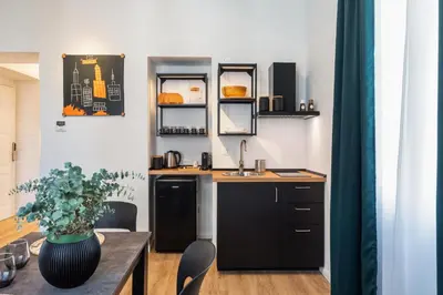 a kitchen with a sink and a table with chairs at Adelante Apartment in Rome