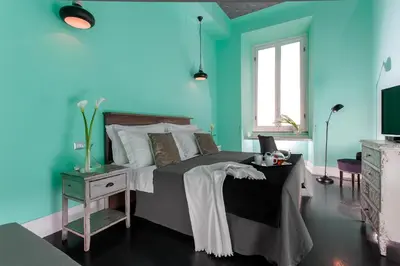 a blue bedroom with a bed and a television at Daniele Manin Roma in Rome