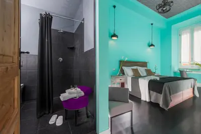 a room with a bed and a bathroom with a shower at Daniele Manin Roma in Rome