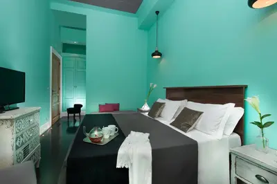a bedroom with a large bed with a blue wall at Daniele Manin Roma in Rome