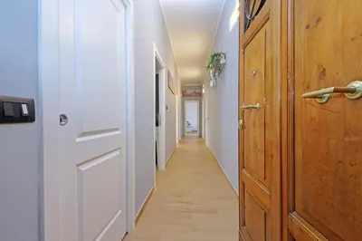 a hallway with a white door and a wooden floor at Misa Guest House San Lorenzo in Rome