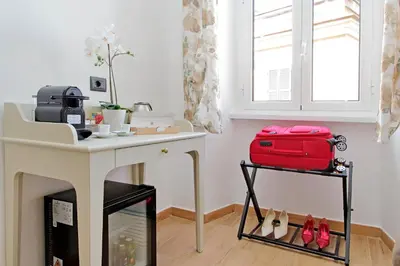 a room with a table with a red suitcase at Misa Guest House San Lorenzo in Rome