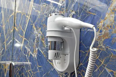a hair dryer is attached to a blue wall at Misa Guest House San Lorenzo in Rome