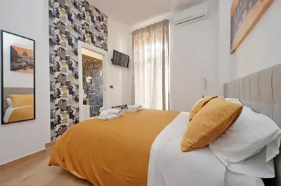 a bedroom with a large bed with a yellow blanket at Misa Guest House San Lorenzo in Rome