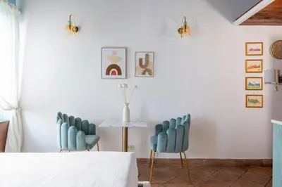 a dining room with blue chairs and a table at Suite Trevi - Charming Loft Near Trevi Fountain in Rome