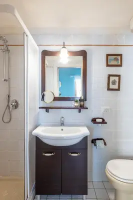a bathroom with a sink and a toilet and a mirror at Suite Trevi - Charming Loft Near Trevi Fountain in Rome