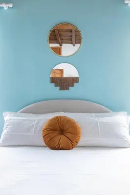a close up of a bed with a pillow and a mirror at Suite Trevi - Charming Loft Near Trevi Fountain in Rome