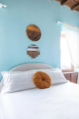 a bedroom with a white bed with a blue wall at Suite Trevi - Charming Loft Near Trevi Fountain in Rome