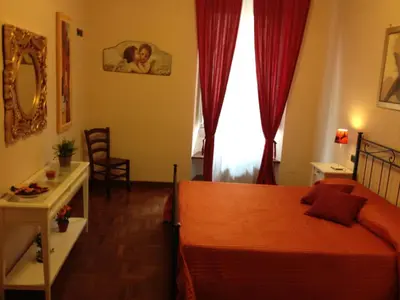 a bedroom with a bed and a table and a window at Holiday Home House Fornaci in Rome