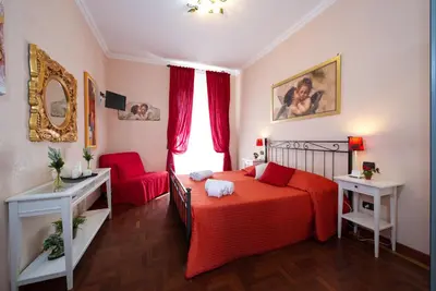 a bedroom with a red bed and a red chair at Holiday Home House Fornaci in Rome