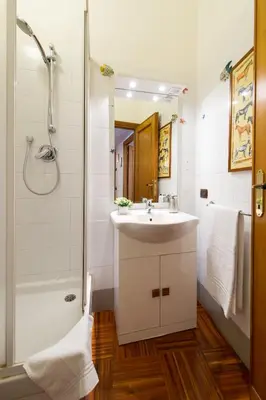 a white bathroom with a sink and a shower at Holiday Home House Fornaci in Rome
