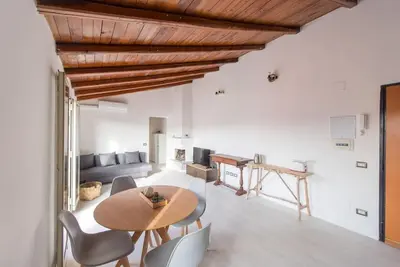 a dining room and living room with a wooden ceiling at San Peter's - Cosy Renovated Penthouse in Rome
