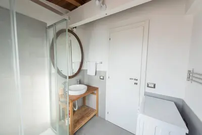 a bathroom with a mirror and a sink at San Peter's - Cosy Renovated Penthouse in Rome