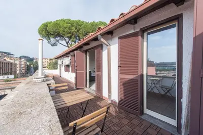 a balcony with two benches and a large window at San Peter's - Cosy Renovated Penthouse in Rome