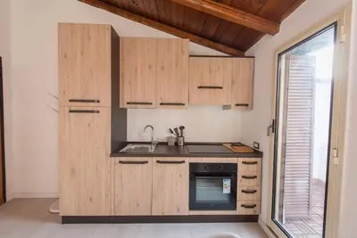 a kitchen with wooden cabinets and a sink and a window at San Peter's - Cosy Renovated Penthouse in Rome