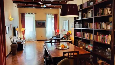 a living room with a table and a book shelf at Benedetta Suite Trastevere in Rome