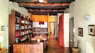 a dining room with a table and bookshelves at Benedetta Suite Trastevere in Rome