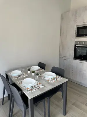 a dining table with plates and chairs in a kitchen at Casa Sofia, a 4 fermate metro dal Vaticano in Rome