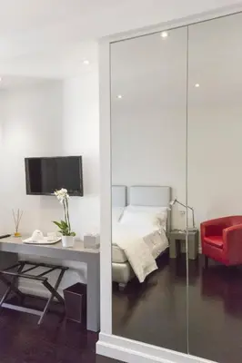 a bedroom with a bed and a desk with a red chair at Xenia Guest House in Rome