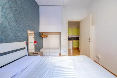 a bedroom with a white bed and a blue wall at Charming suite with view in the heart of Rome in Rome