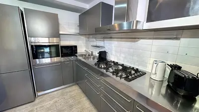 a stainless steel kitchen with a stove and refrigerator at D10S SANPIETRO in Rome
