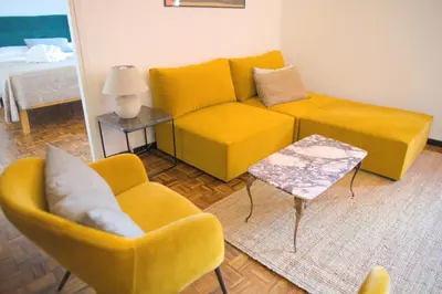 a living room with a yellow couch and a table at Fontana di Trevi sweet apartment in Rome