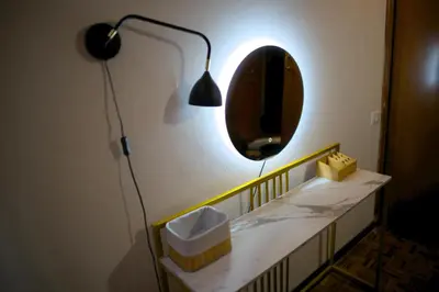a bathroom with a mirror and a lamp and a sink at Fontana di Trevi sweet apartment in Rome