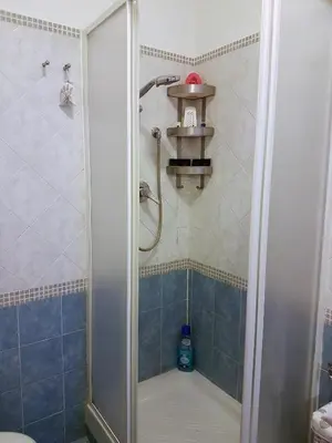 a shower in a bathroom with blue tiles at Il Salotto di via Giulia in Rome