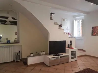 a living room with a flat screen tv and a staircase at Il Salotto di via Giulia in Rome