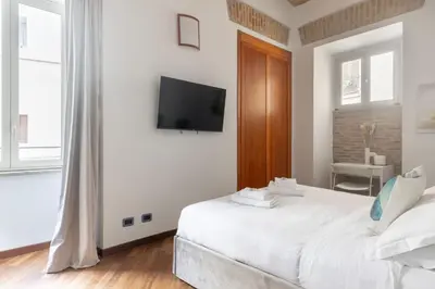 a plate of croissants and orange juice and a newspaper at Colosseum superior suites in Rome