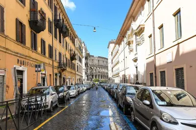 a row of cars parked on a city street at Colosseum superior suites in Rome