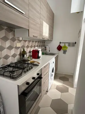 a kitchen with a stove and a washing machine at Renovated studio near the Vatican in Rome