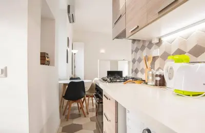 a kitchen with a white counter top and a table at Renovated studio near the Vatican in Rome