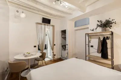 a bedroom with a white bed and a table and chairs at Fiori Suite in Rome