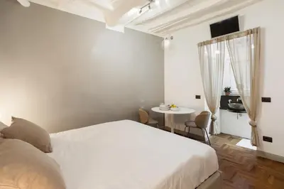 a bedroom with a white bed and a table at Fiori Suite in Rome